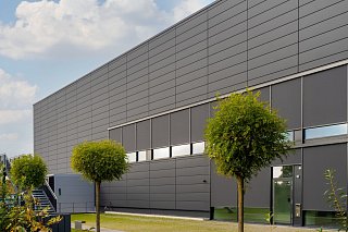 Außenansicht einer Halle, wobei die Veglasungen mit Fassadentextilscreens von Roma ausgestattet sind