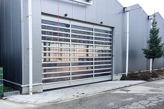 Transparentes Schnelllauftor an Industriegebäude