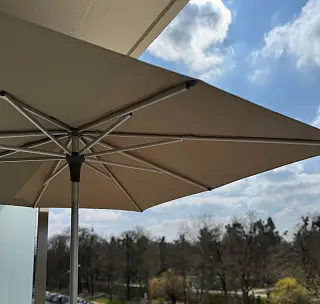 Beiger Sonnenschirm auf einem Balkon, umgesetzt von der Schuhbauer junior GmbH